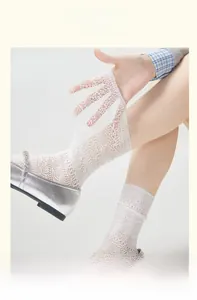 Detailed view of white mesh lace knee-high socks featuring delicate floral hollow patterns