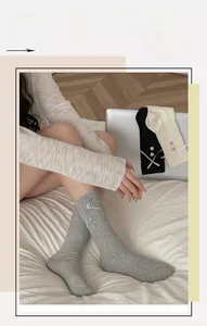 Detail of ribbed cotton socks featuring decorative side ribbon bows and vintage buttons