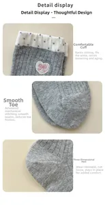 Detail view of pink bow heart embroidery and dotted elastic cuffs on grey knitted socks