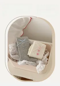 Detail of ribbed knit socks with decorative bows and buttons in a pink storage box