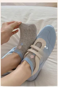 Detail of grey thin no-show socks showing breathable fabric and elastic blue ribbed edge