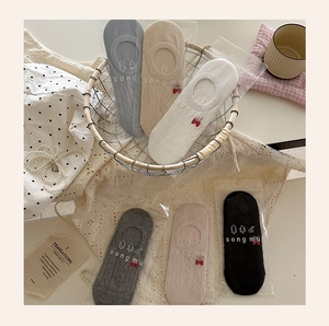 Flat lay of six pairs of low-cut cotton socks with bow and tree embroidery detail