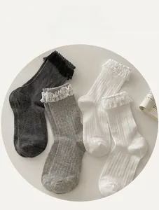 Detailed view of women's ribbed crew socks with delicate lace trim in grey and white