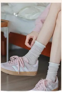 Detailed macro view of light gray mesh socks with white ribbed cuffs and breathable texture