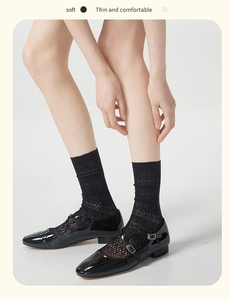 Detail of black mesh lace socks with hollow pattern worn with black Mary Jane shoes