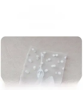 Détail de chaussettes en tulle transparent à pois blancs et bords-côtes élastiques