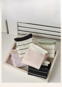 Close-up of colorful waffle knit cotton socks with striped details in a wooden tray