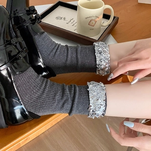 Sparkling grey slouch socks with silver sequins and rib knit texture shown with black shoes