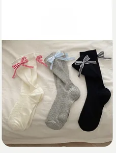Détail des nœuds décoratifs sur un lot de chaussettes mi-mollet en coton côtelé