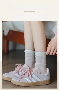 Close-up of elastic ribbed cuff and breathable mesh knit pattern on beige crew socks
