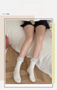 Dettaglio di calze in maglia bianca con volant a quadretti bianchi e neri in stile giapponese