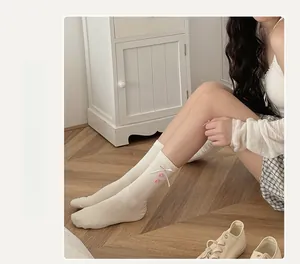 Detail of cream cotton socks with pink ribbon bows and buttons in Japanese style