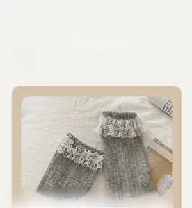 Detailed view of grey ribbed cotton socks with layered white lace trims and elastic cuffs