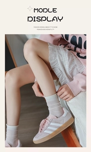 Close-up of pink suede sneakers with white stripes and matching striped socks for women