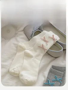Detail of ribbed crew socks with a pink velvet bow decoration and ballet flat shoes