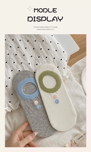 Detail of grey and beige invisible cotton socks featuring embroidery and ribbed cuffs