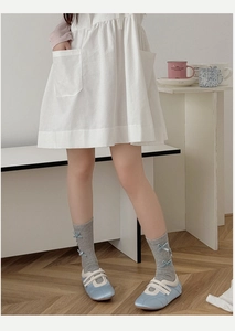 Detail of grey calf socks with blue ribbon bows paired with Mary Jane shoes and dress
