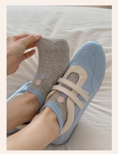 Close-up of gray low-cut socks with colorful dots embroidery and blue Mary Jane shoes