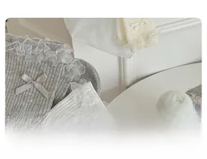 Close-up of grey and beige lace crew socks featuring ribbon bows and organza trim