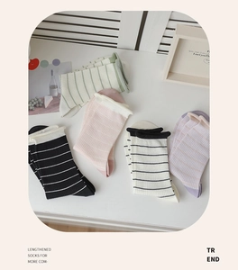 Flat lay of five striped and checkered cotton mid-calf socks in soft pastel colors
