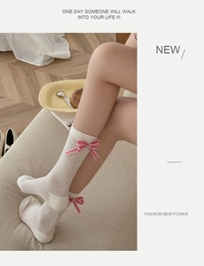 Détail de chaussettes blanches côtelées avec nœuds vichy rouges et blancs style ballet