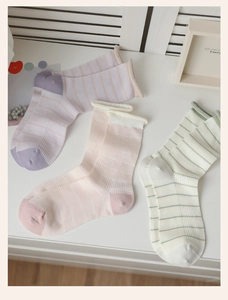 Detailed view of striped mesh crew socks in pastel purple, pink, and cream with rolled cuffs