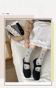 Détail de chaussettes en maille à motifs de cœurs avec bordure ondulée délicate