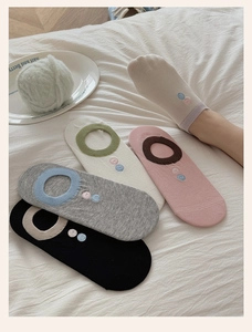 Detailed view of colorful no-show socks featuring non-slip heels and polka dot embroidery