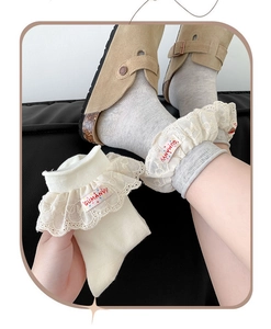 Gros plan de chaussettes en coton style lolita avec volants et étiquettes brodées