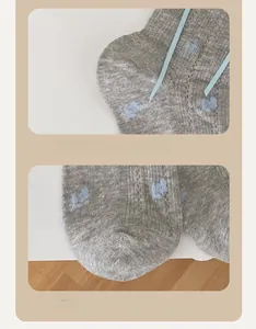 Detail of gray knitted socks featuring blue cloud patterns and reinforced heel and toe
