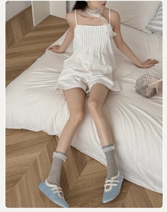 Close-up of light grey knit socks with white lace trim and blue Mary Jane shoes