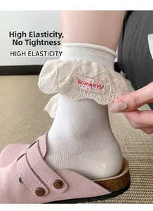 Détail de chaussettes blanches élastiques avec bordure en dentelle et étiquette rose
