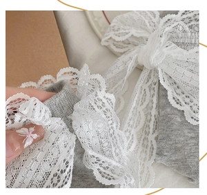 Detailed view of grey lace crew socks with delicate white floral embroidery edges