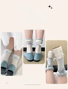 Detail of ballet style white and blue knee-high socks with cute bows and bear patterns