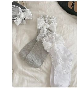 Detail of sweet Lolita crew socks with delicate lace bows in white and grey colors