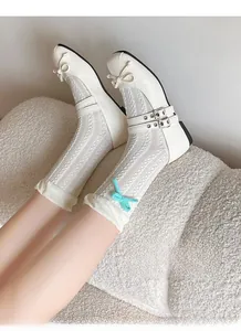 Detail of white Mary Jane shoes and cable knit socks with a green bow and high elasticity