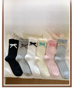 Flat lay of colorful bow ruffle socks in pink, yellow, blue, white, gray and black colors