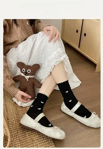 Détails de chaussettes noires à petits cœurs blancs et bords à volants doux