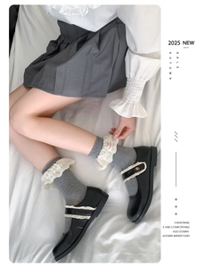Détail de chaussettes grises avec bordure en dentelle blanche et broderie style Lolita