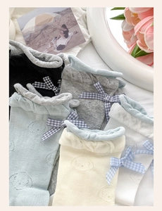 Detail of ballet style socks with bow accents and cartoon puppy embroidery in pastel colors