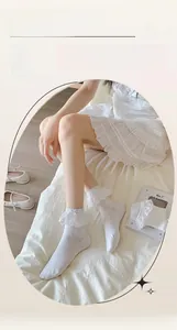 Close-up of white lace trim socks featuring delicate embroidery and soft cotton texture
