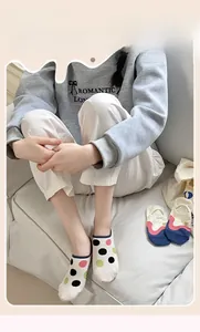 Detail of breathable low cut liner socks with colorful polka dots on a model at home