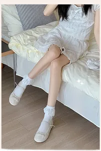 Close-up of white lace ruffle short socks paired with elegant white Mary Jane shoes