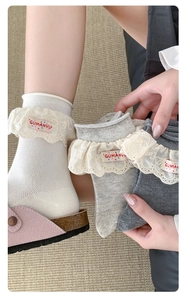 Gros plan de chaussettes style lolita avec bordures en dentelle et étiquettes brodées