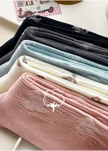 Detail of colorful combed cotton mid-tube socks with vertical stripes and bow patterns