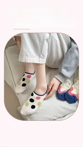 Detail showing white low-cut invisible socks with colorful polka dots and navy trim