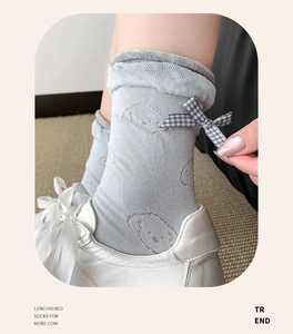 Detail of ballet style knit socks with puppy embroidery and checkered bow ornament