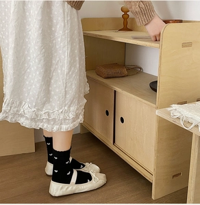 Détail de chaussettes noires à cœurs blancs et chaussures Mary Jane blanches style japonais