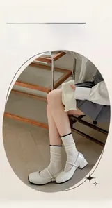 Detail of white mesh breathable slouch socks with black wavy edges and knit texture
