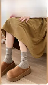 Gray ribbed wool socks with egg label paired with brown corduroy skirt and suede mules